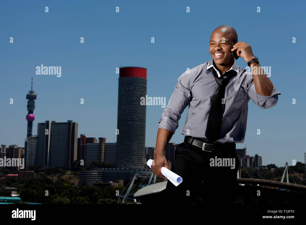 Business man colloqui su cellulare con cityscape in background Foto Stock