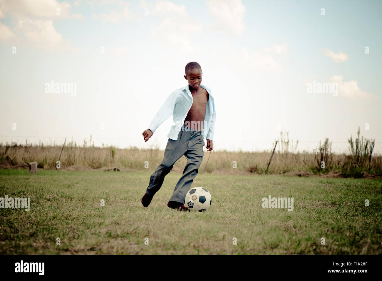 African scolaro che giocano a calcio Foto Stock