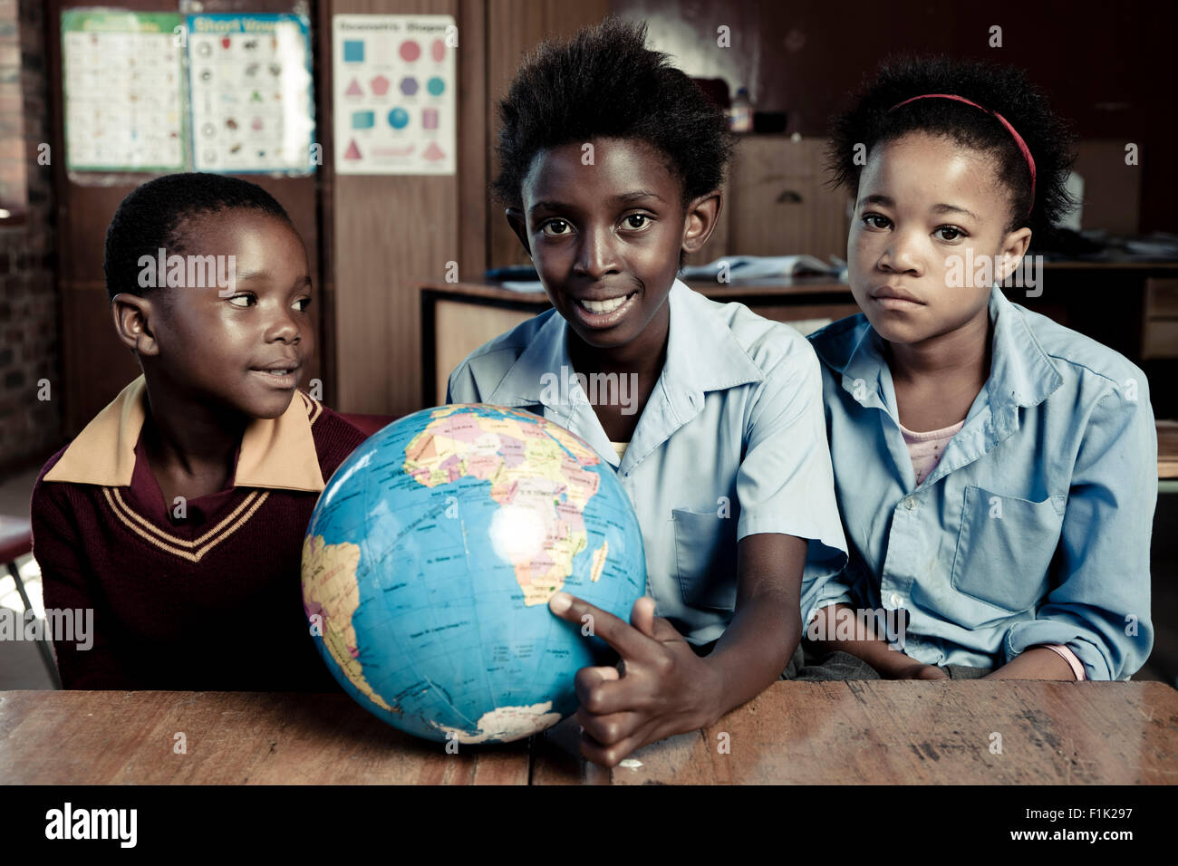 Femmina africana gli studenti in possesso di un globo terrestre, sorridente in telecamera Foto Stock