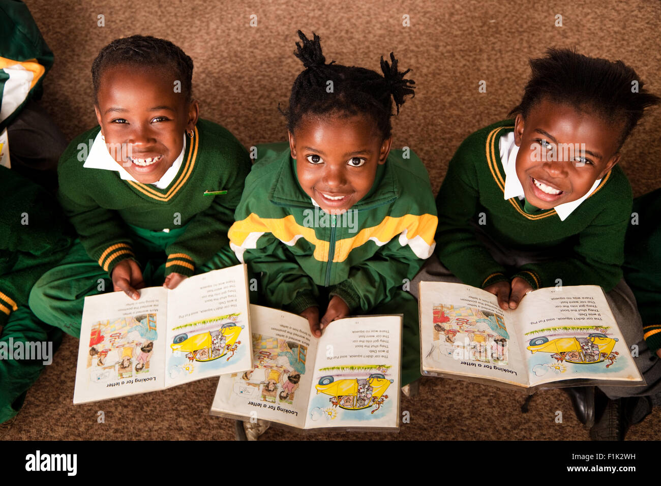 Ragazze in uniforme scolastica con libri e sorridente fino alla fotocamera, Meyerton scuola primaria, Meyerton, Gauteng Foto Stock