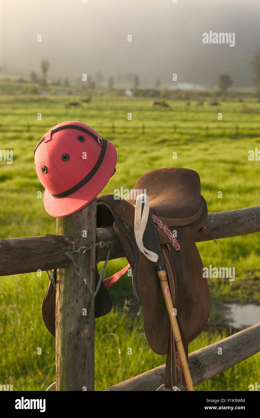 Sella, casco e Polo Mallet sulla recinzione di legno Foto Stock