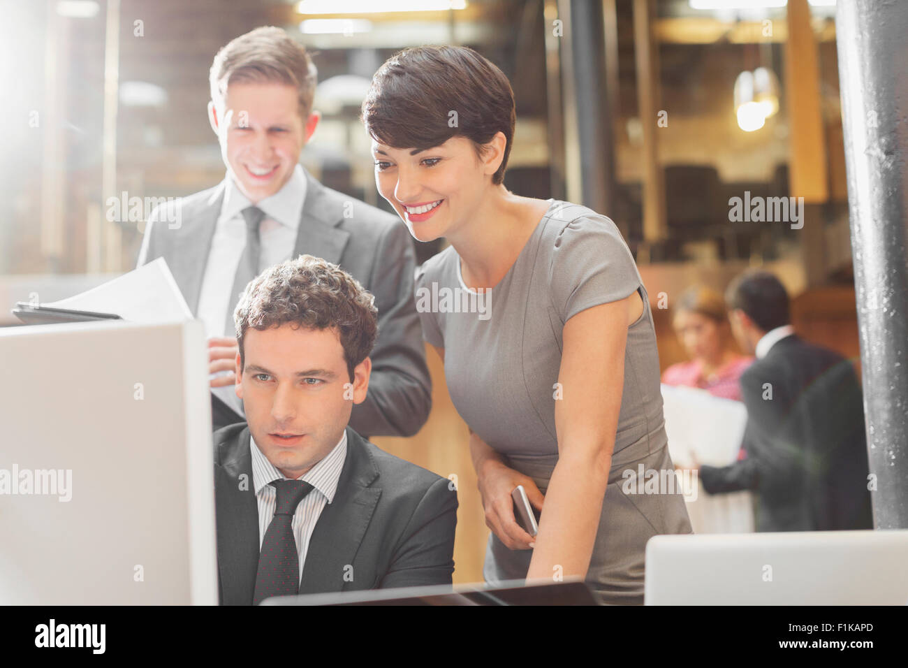 Sorridente business persone che lavorano al computer in ufficio Foto Stock