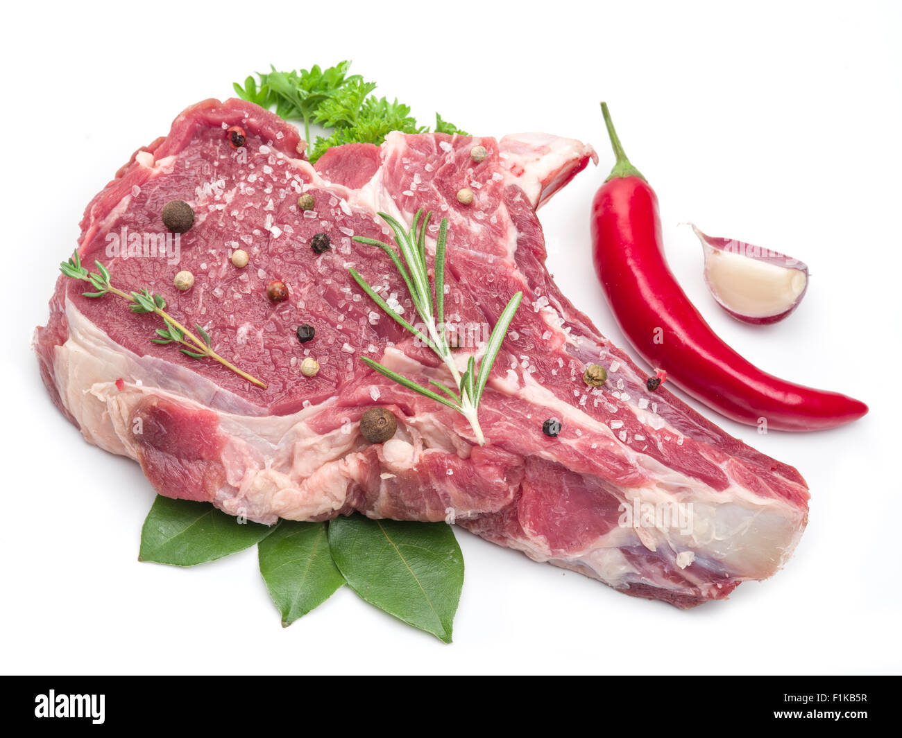 Raw bistecca di manzo con spezie sullo sfondo bianco. Foto Stock