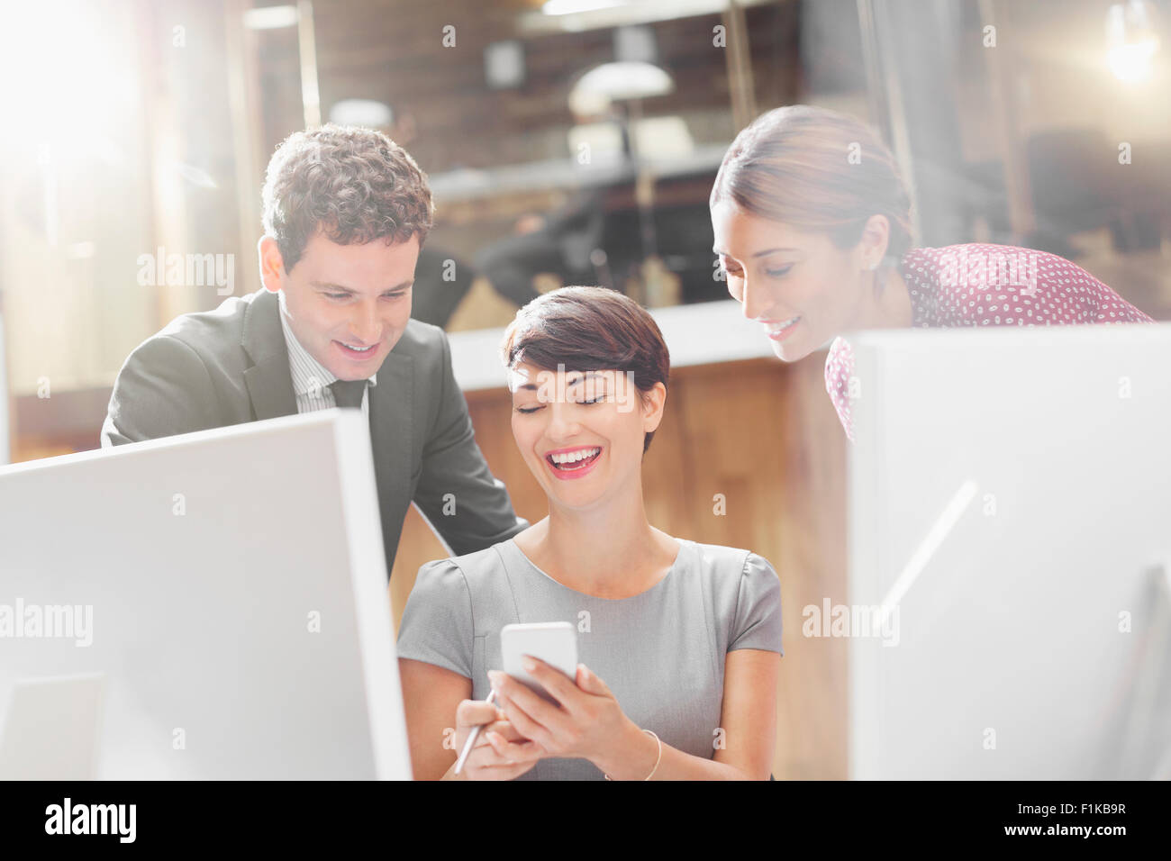 La gente di affari texting con il cellulare in ufficio Foto Stock
