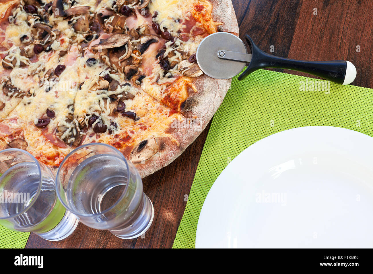 Ora di pranzo, greca Pizza sul tavolo e accessori. Foto Stock