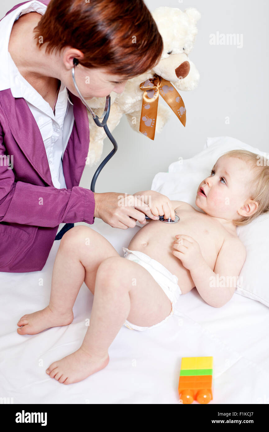 Un pediatra ascoltando un bambino di respirazione Foto Stock