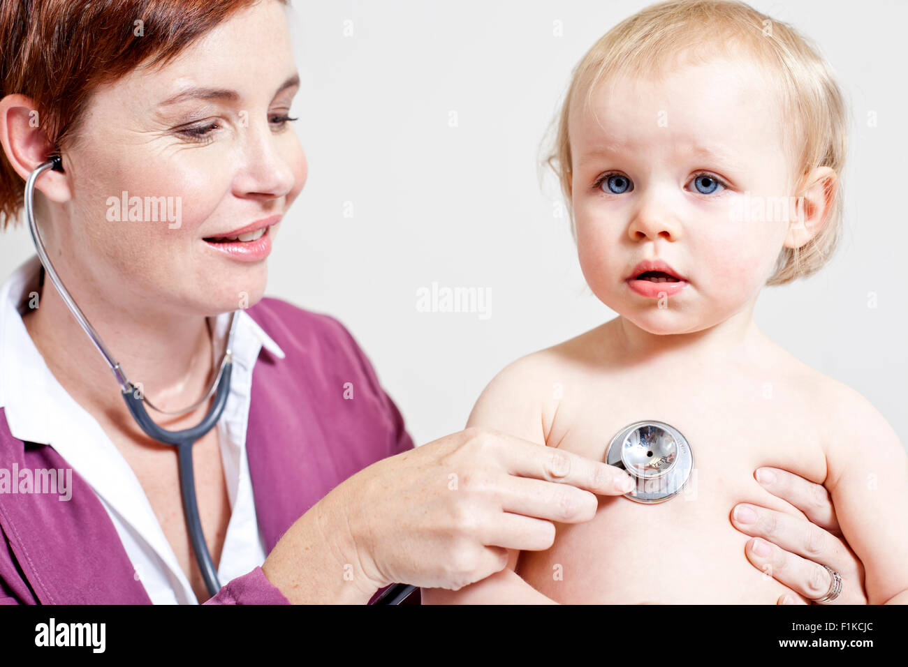 Un pediatra ascoltando un bambino di respirazione Foto Stock