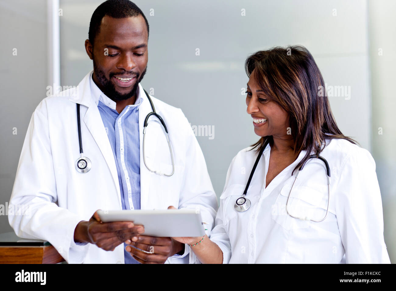 Due medici di andare oltre i report su un tablet Foto Stock