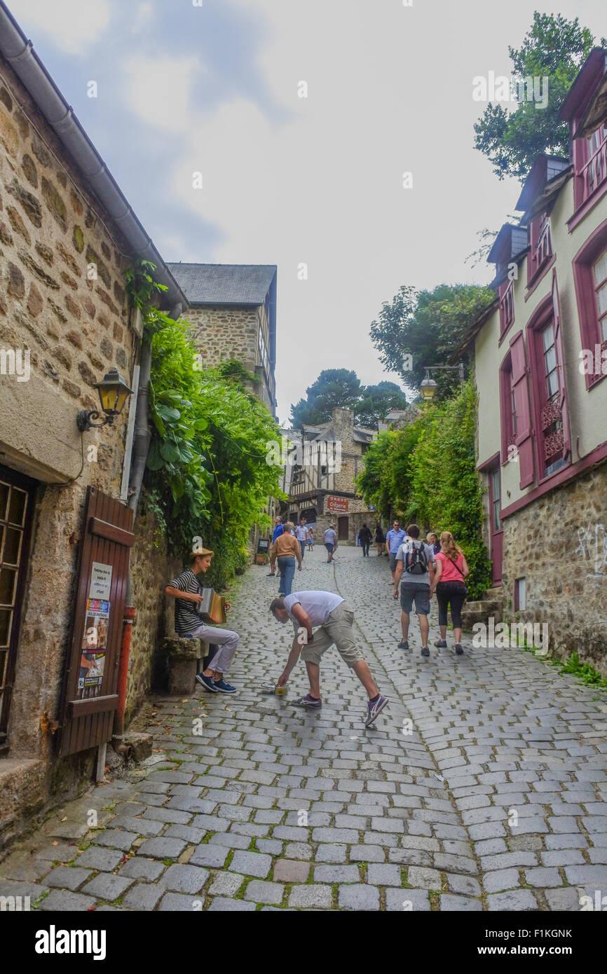 Giovane musicista di strada a suonare la sua fisarmonica sulla Rue du Petit Fort, Dinan, Brittany, Francia Foto Stock