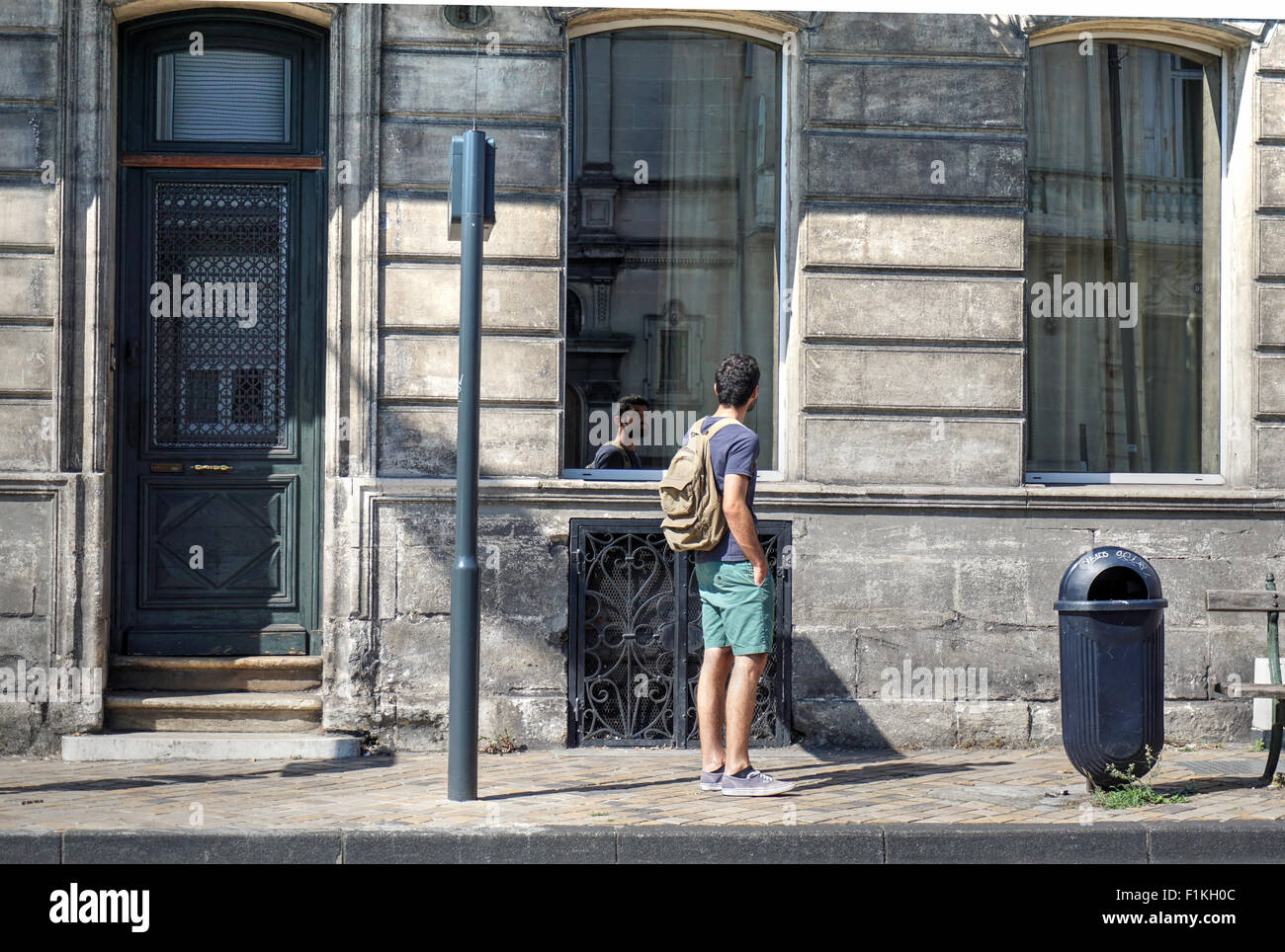 BORDEAUX, Francia, settembre 03, 2015 : un uomo in cerca di se stesso in vetro riflettente di un tipico palazzo di vetro in Bordeaux. Foto Stock