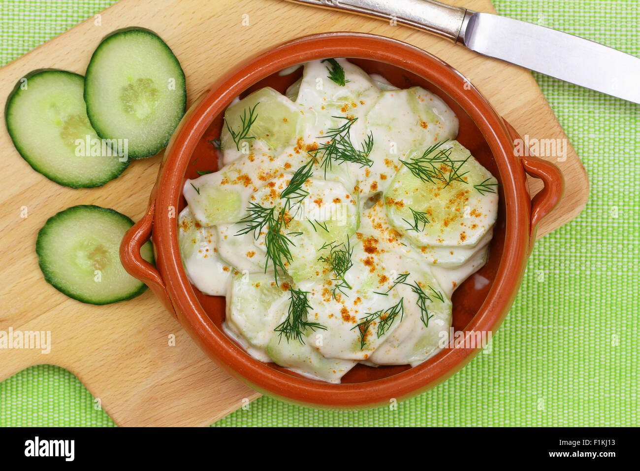 Insalata di cetrioli con panna acida e aneto fresco nel recipiente di argilla Foto Stock