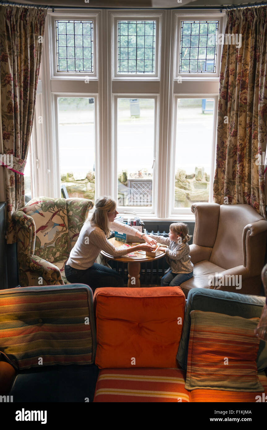 Una madre gioca un gioco con la figlia in un pub UK Foto Stock