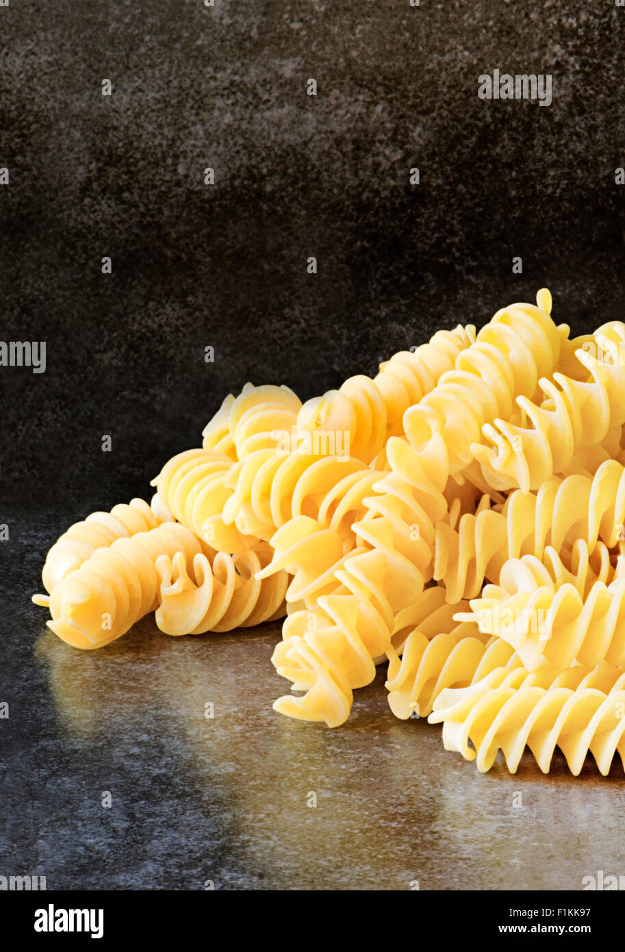 Materie non cotti Fusilli shot utilizzando la finestra luce su uno sfondo di ardesia, un sacco di spazio per il testo e per lo spazio di copia . Foto Stock
