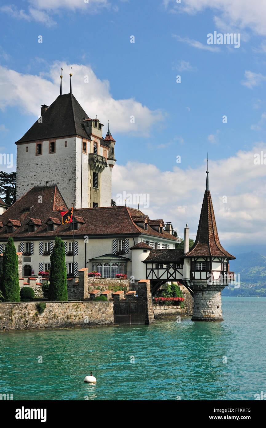 L'acqua castello Schloss Oberhofen lungo la Tunersee / Lago di Thun in Alpi Bernesi, Svizzera Foto Stock