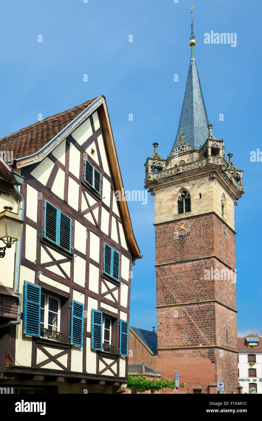 Metà tipico edificio con travi di legno e la cappella e la Torre Saint-Odile Street Obernai Alsace Francia Foto Stock