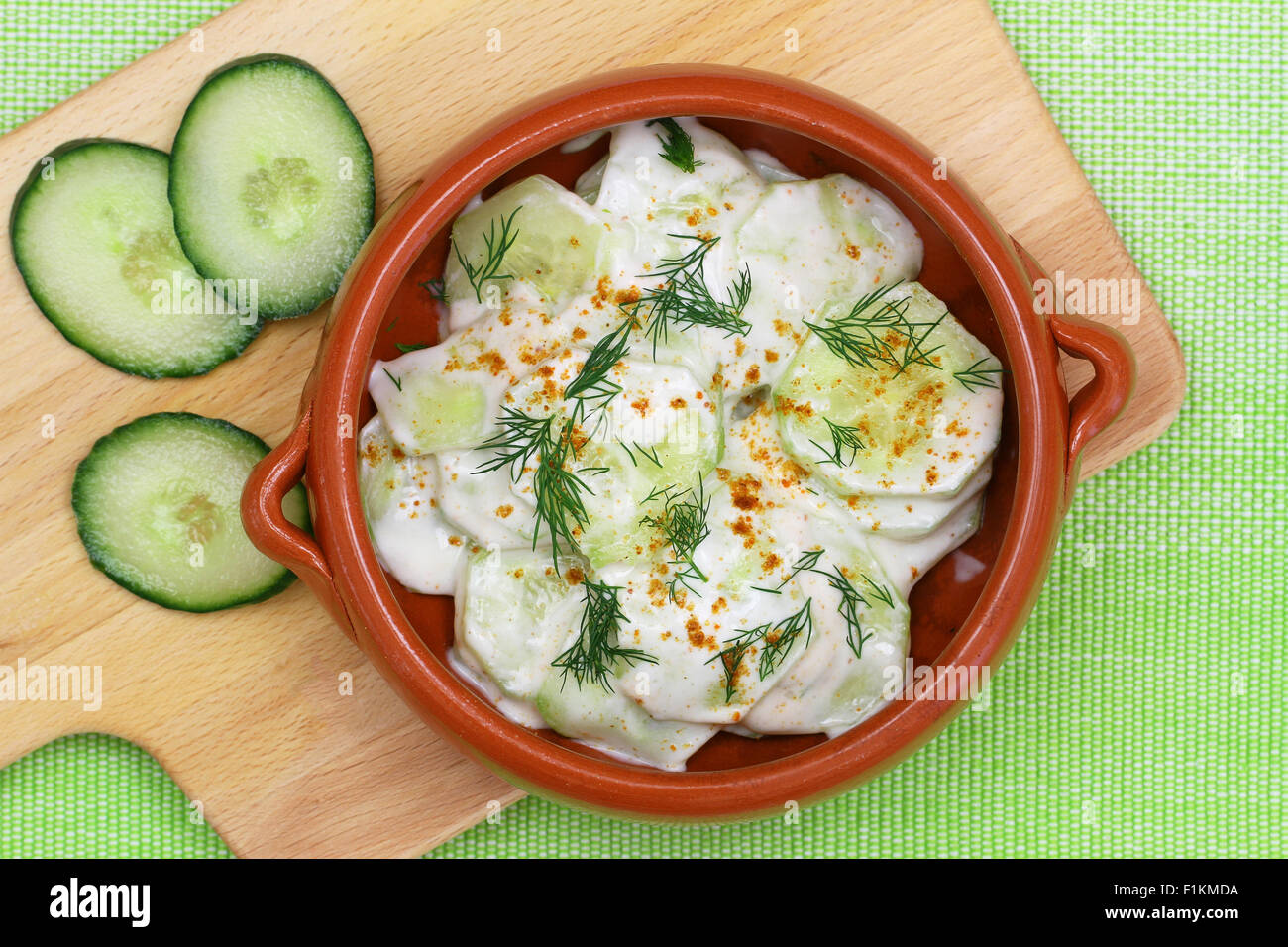 Insalata di cetrioli con panna acida e aneto fresco nel recipiente di argilla, close up Foto Stock