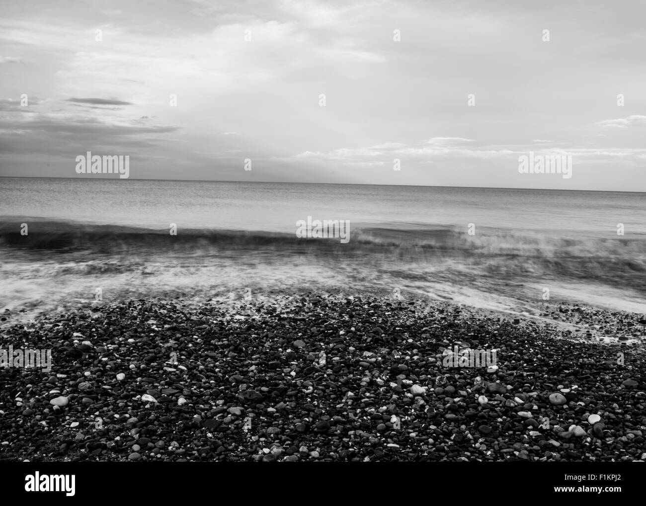 Una selvaggia spiaggia di ciottoli in bianco e nero Foto Stock