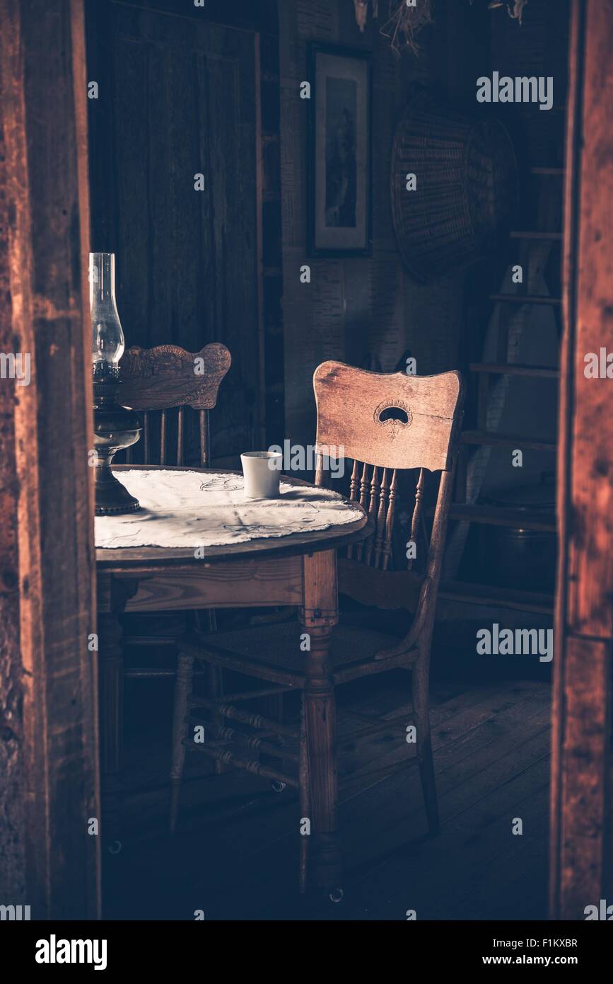 Vintage Home interno con il vecchio tavolo in legno invecchiato e sedia. Camera retrò con tavolo da caffè. Foto verticale Foto Stock