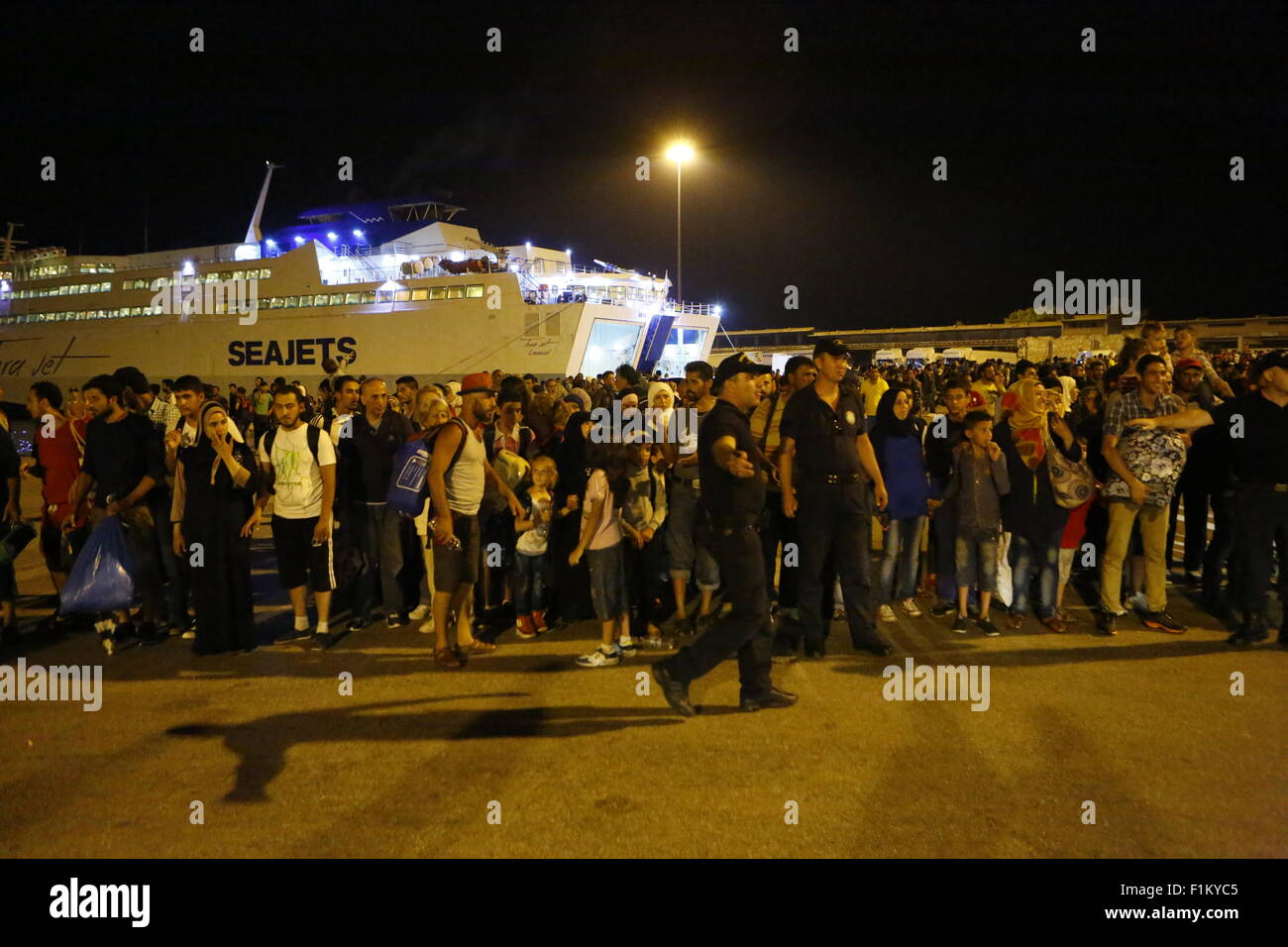 Atene, Grecia. Il 3 settembre 2015. I rifugiati di attendere presso il porto del Pireo per il bus che li porterà alla stazione ferroviaria per essere portati in Atene. Migliaia di rifugiati sono arrivati nel porto del Pireo a bordo il governo chartered Tera Jet traghetto dall'isola greca di Lesbo. Centinaia e centinaia di rifugiati, per la maggior parte dalla Siria e Afghanistan arrivare sulle isole greche ogni settimana, aggiungendo alla già numero di migliaia di profughi già sulle isole greche. Credito: Michael Debets/Alamy Live News Foto Stock