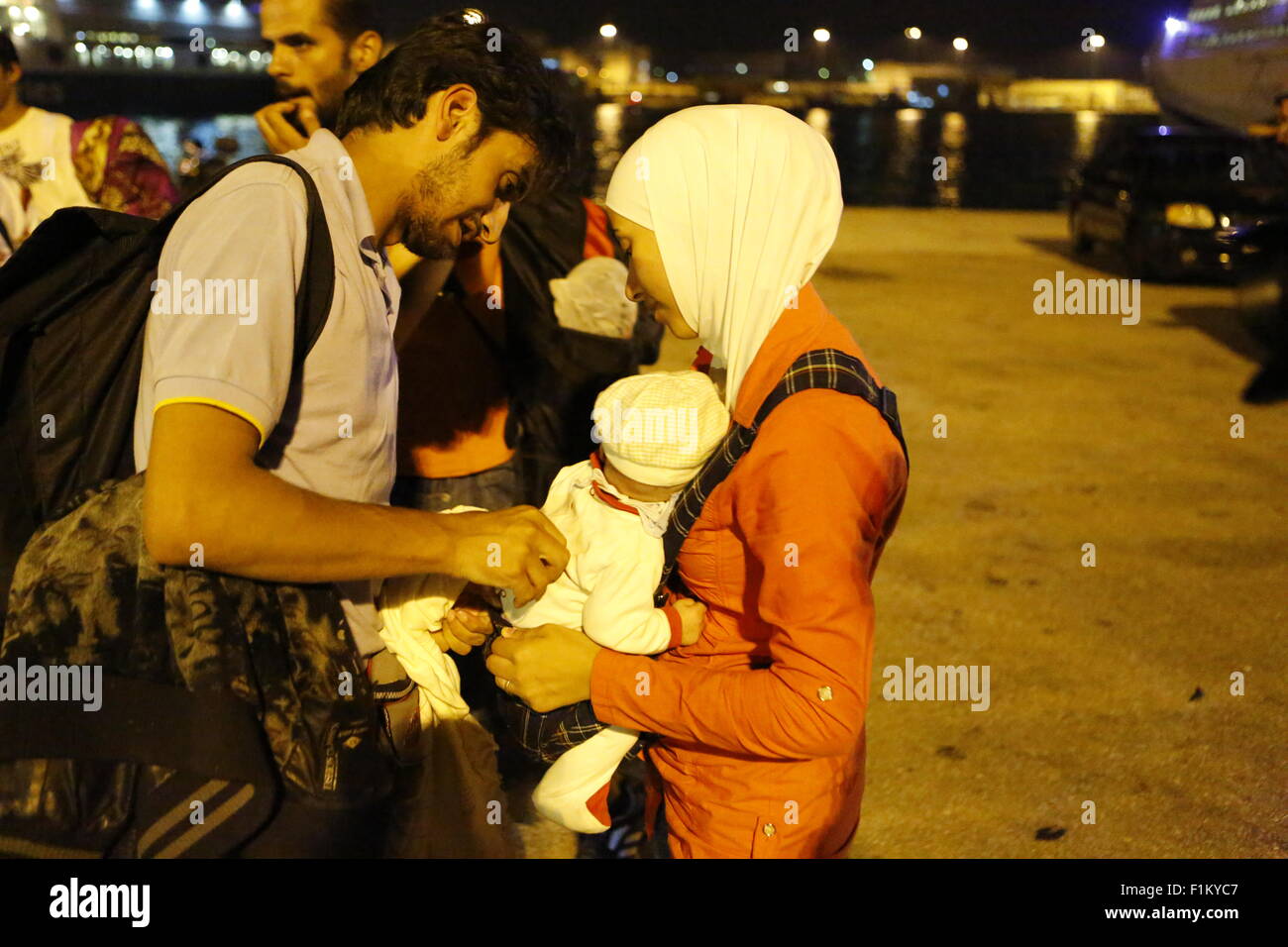 Atene, Grecia. Il 3 settembre 2015. Un rifugiato giovane attende dopo la loro giovane baby al Porto del Pireo. Migliaia di rifugiati sono arrivati nel porto del Pireo a bordo il governo chartered Tera Jet traghetto dall'isola greca di Lesbo. Centinaia e centinaia di rifugiati, per la maggior parte dalla Siria e Afghanistan arrivare sulle isole greche ogni settimana, aggiungendo alla già numero di migliaia di profughi già sulle isole greche. Credito: Michael Debets/Alamy Live News Foto Stock