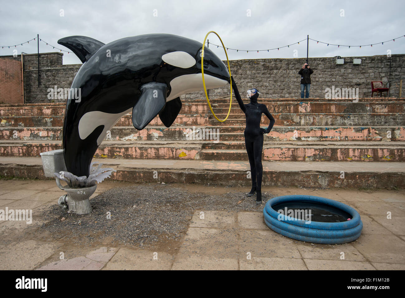Un modello di balena killer salta fuori di un wc come parte di Banksy's Dismaland Bemusement park pop-up mostra a Weston-Super-Mare. Foto Stock