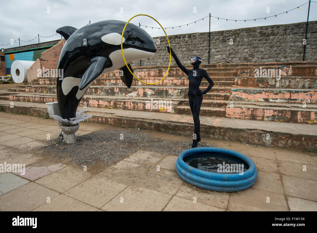 Un modello di balena killer salta fuori di un wc come parte di Banksy's Dismaland Bemusement park pop-up mostra a Weston-Super-Mare. Foto Stock