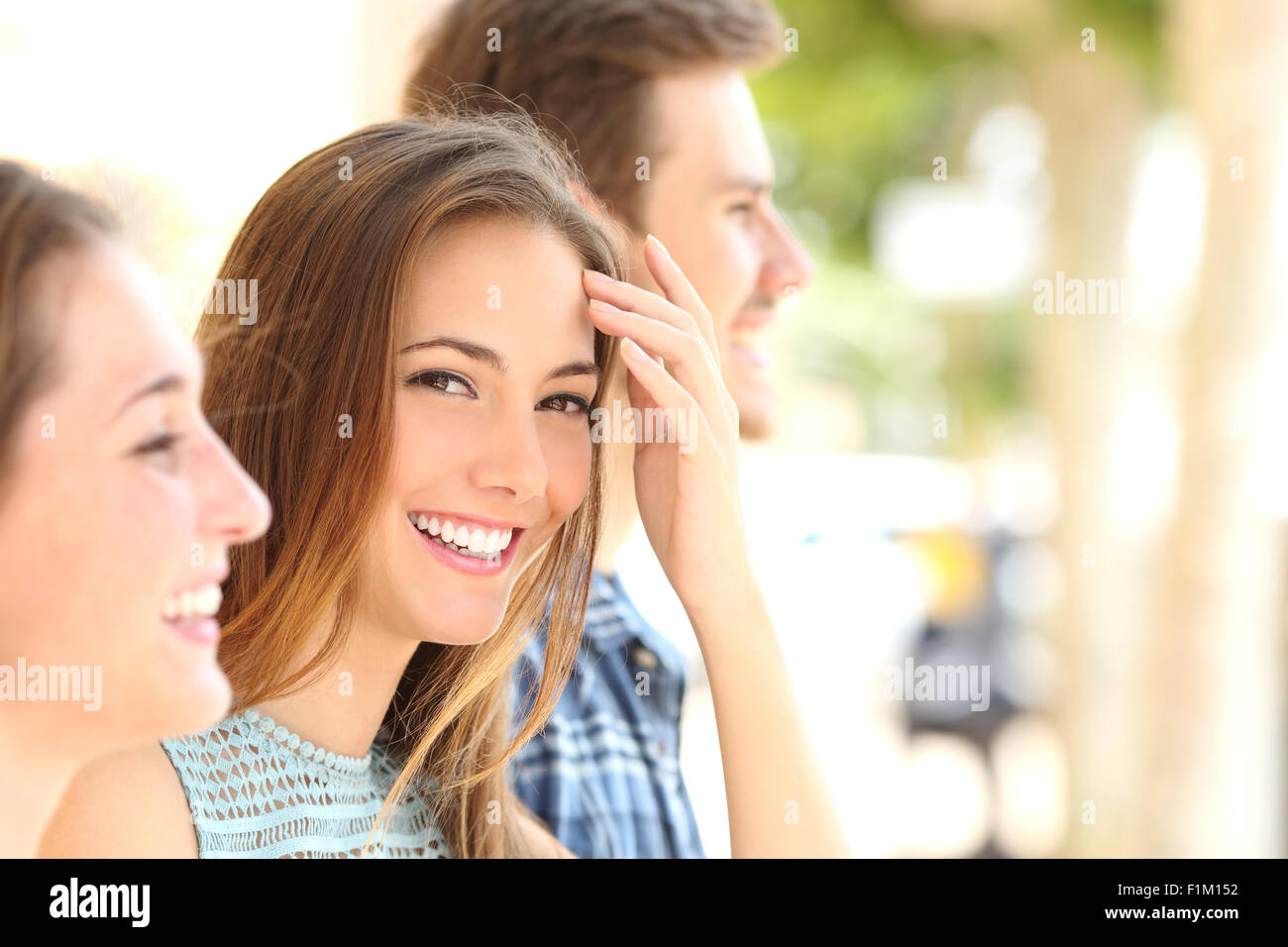 La bellezza della donna con sorriso bianco e denti tra amici per la strada Foto Stock