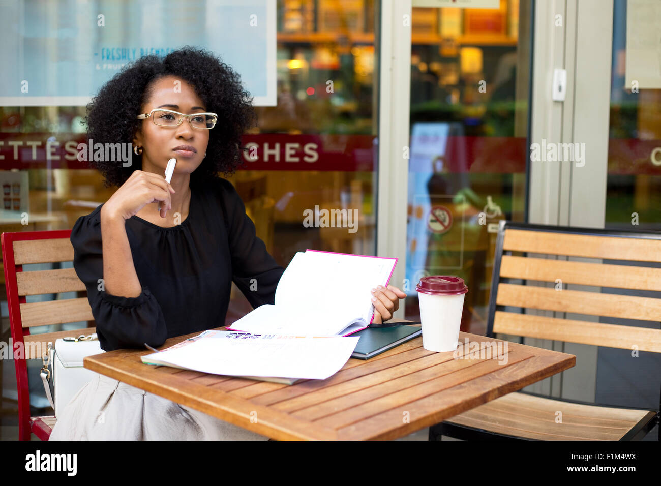 Giovane donna che guarda pensieroso presso la caffetteria Foto Stock