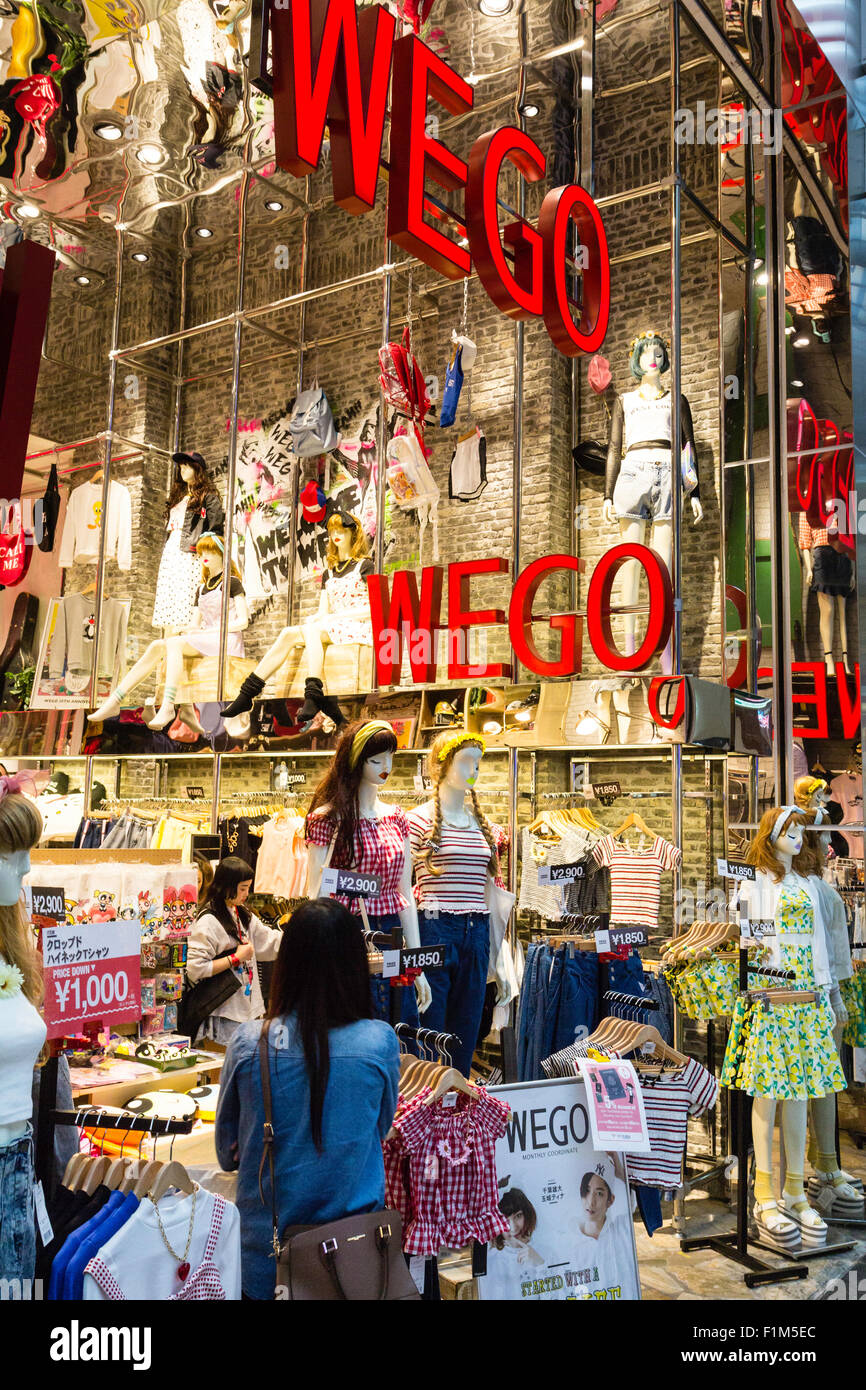 Giappone, Osaka. Il Shinsaibashi Wego fashion boutique di abbigliamento, guardando all'interno della parete di mattoni in negozio con molti monitor, i clienti all'interno di negozi. Foto Stock