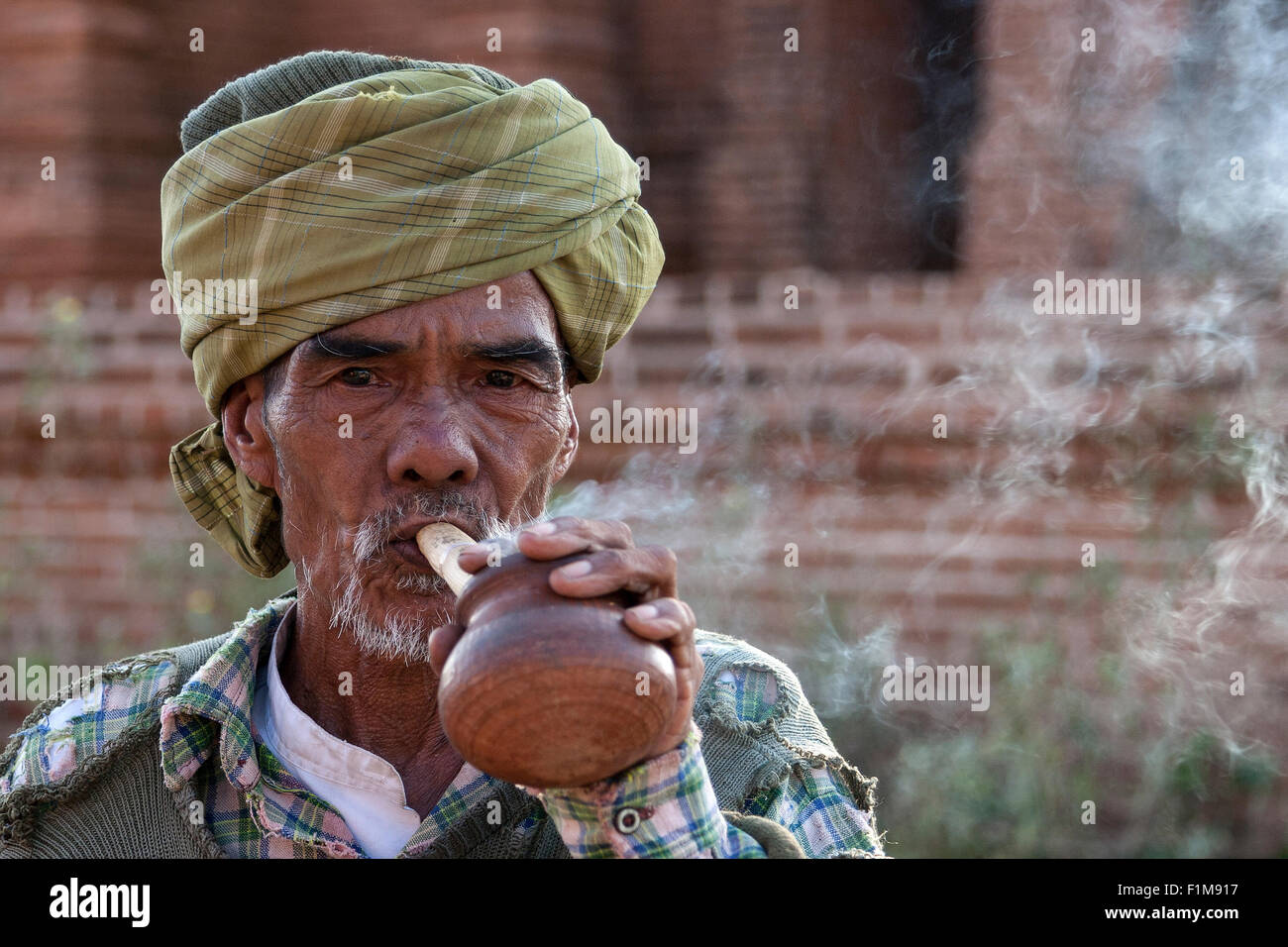 Vecchio indigeni testa di uomo con turbante, fumare un sigaro Cheeroot, ritratto, Bagan, Mandalay regione, Myanmar Foto Stock