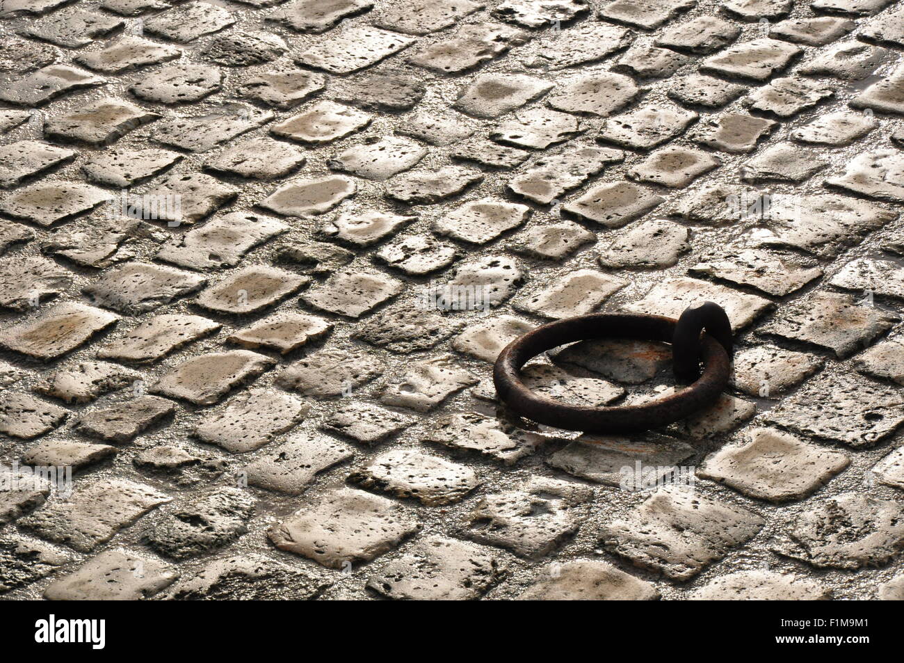 Rusty anello di ormeggio in acciottolato sulla banchina Foto Stock