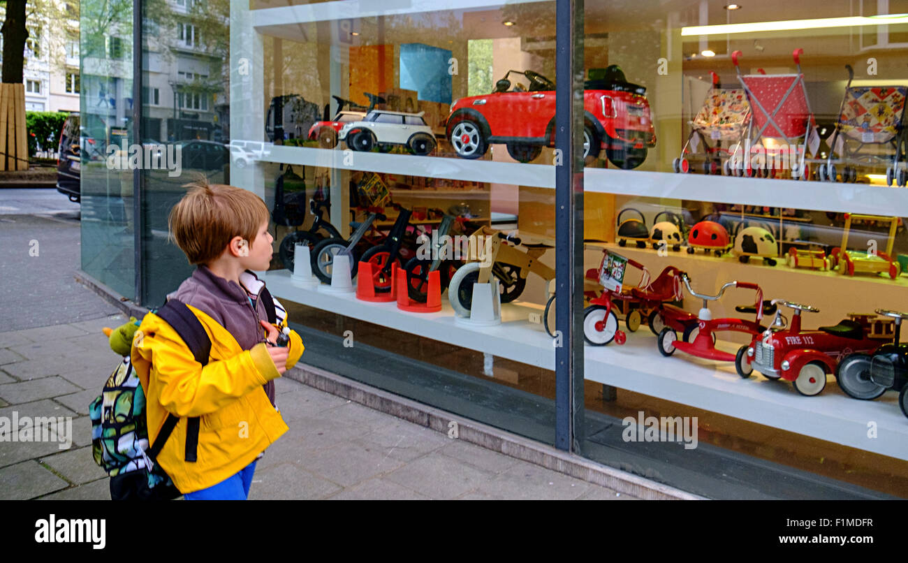 Boy kid bambino voglia guardare alla ricerca finestra toyshop Foto Stock