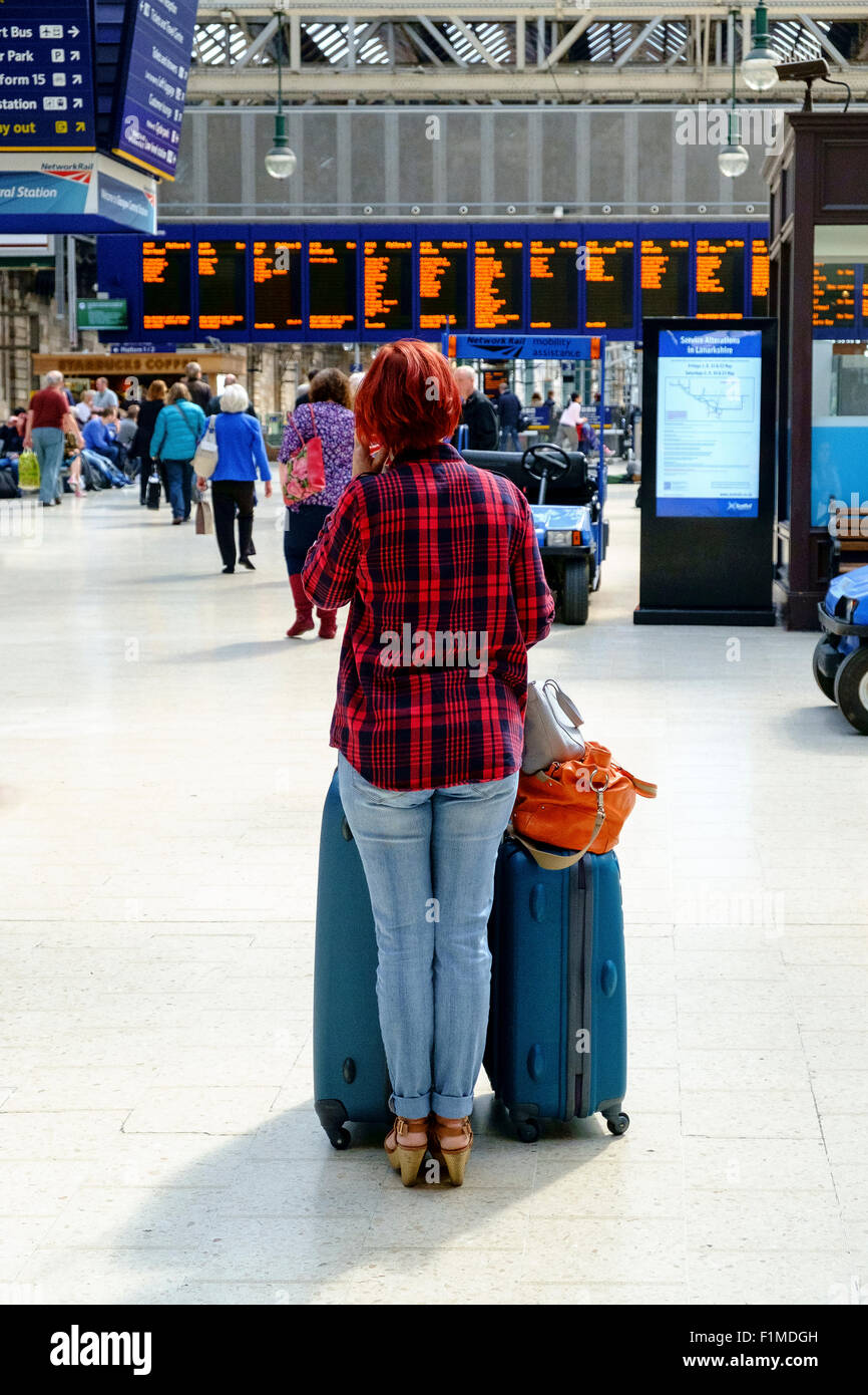 La donna in attesa alla stazione ferroviaria di bagaglio bagagli regno unito Foto Stock