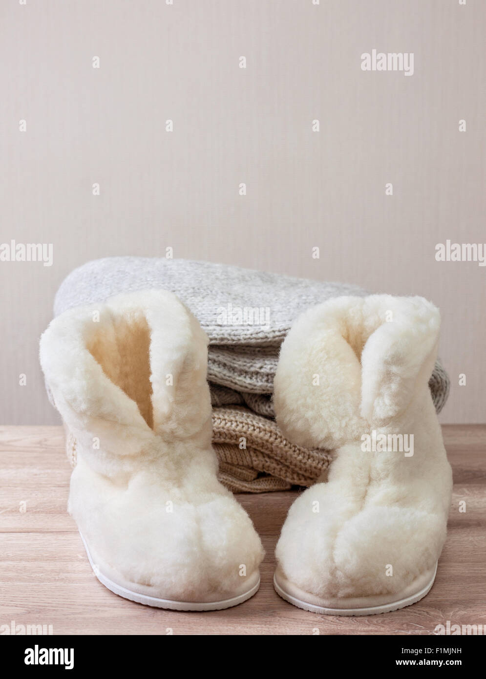 Coppia di caldo inverno pantofole di pelle di pecora (alpaca), filati di  lana, ago da cucito su una pila di calda panni di lana (messa a fuoco  selettiva Foto stock - Alamy