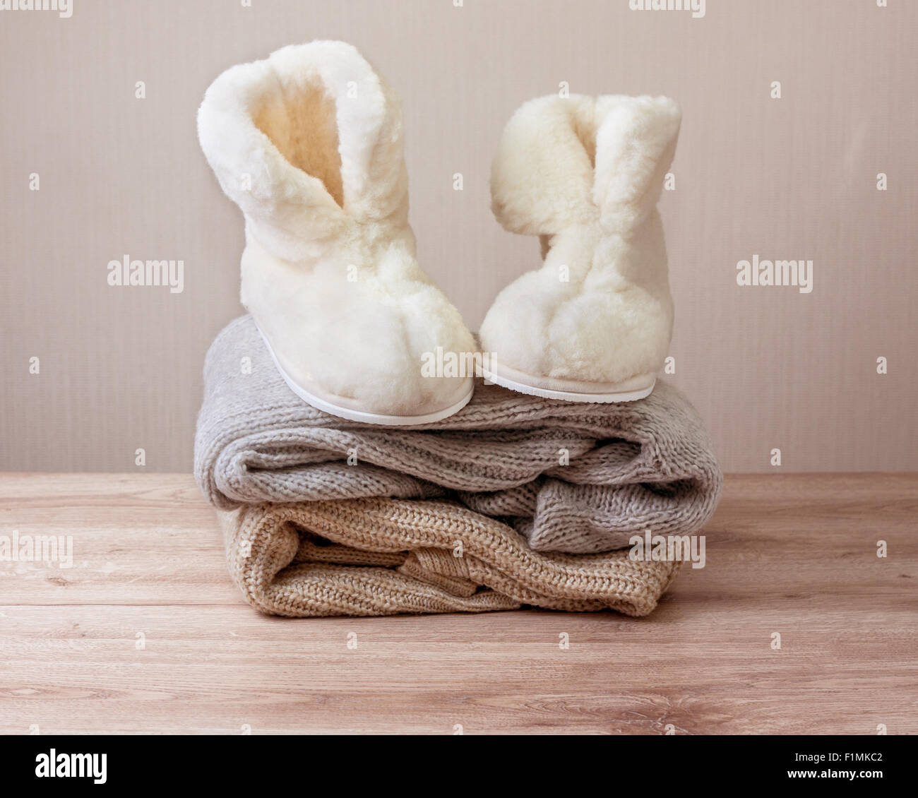 Coppia di caldo inverno pantofole di pelle di pecora (alpaca) sulla pila di calda panni di lana (messa a fuoco selettiva) Foto Stock