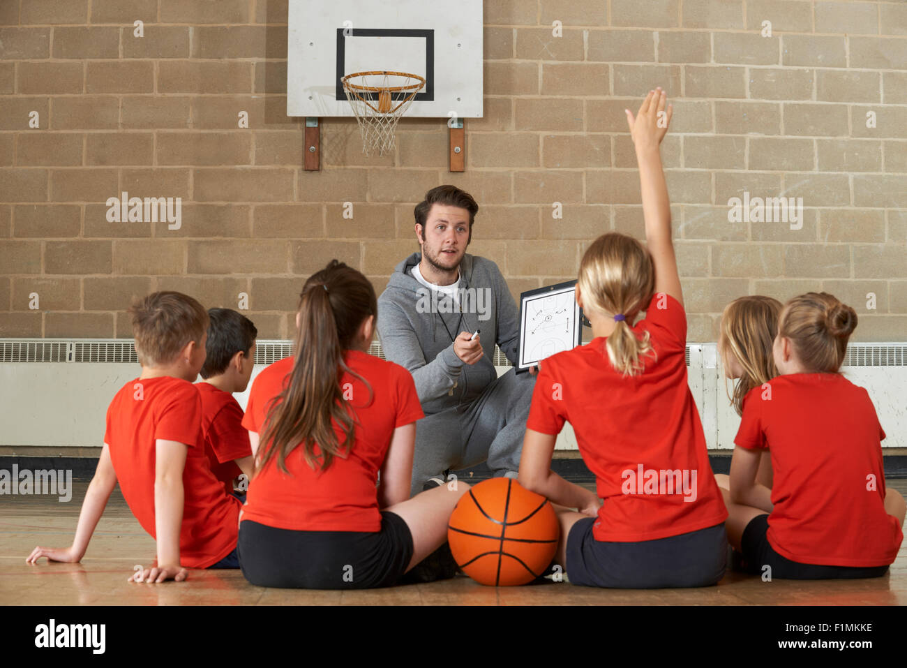 Allenatore dando Team parlare alla scuola elementare della squadra di basket Foto Stock