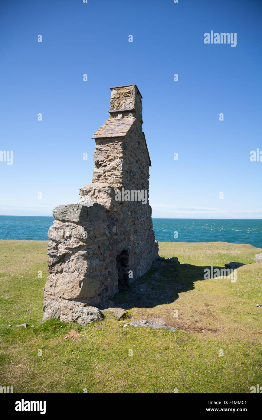 Resti di edificio in pietra / gable end con camino su una scogliera a Porth Ysgaden, Tudweiliog, Llyn Peninsula, il Galles del Nord Foto Stock