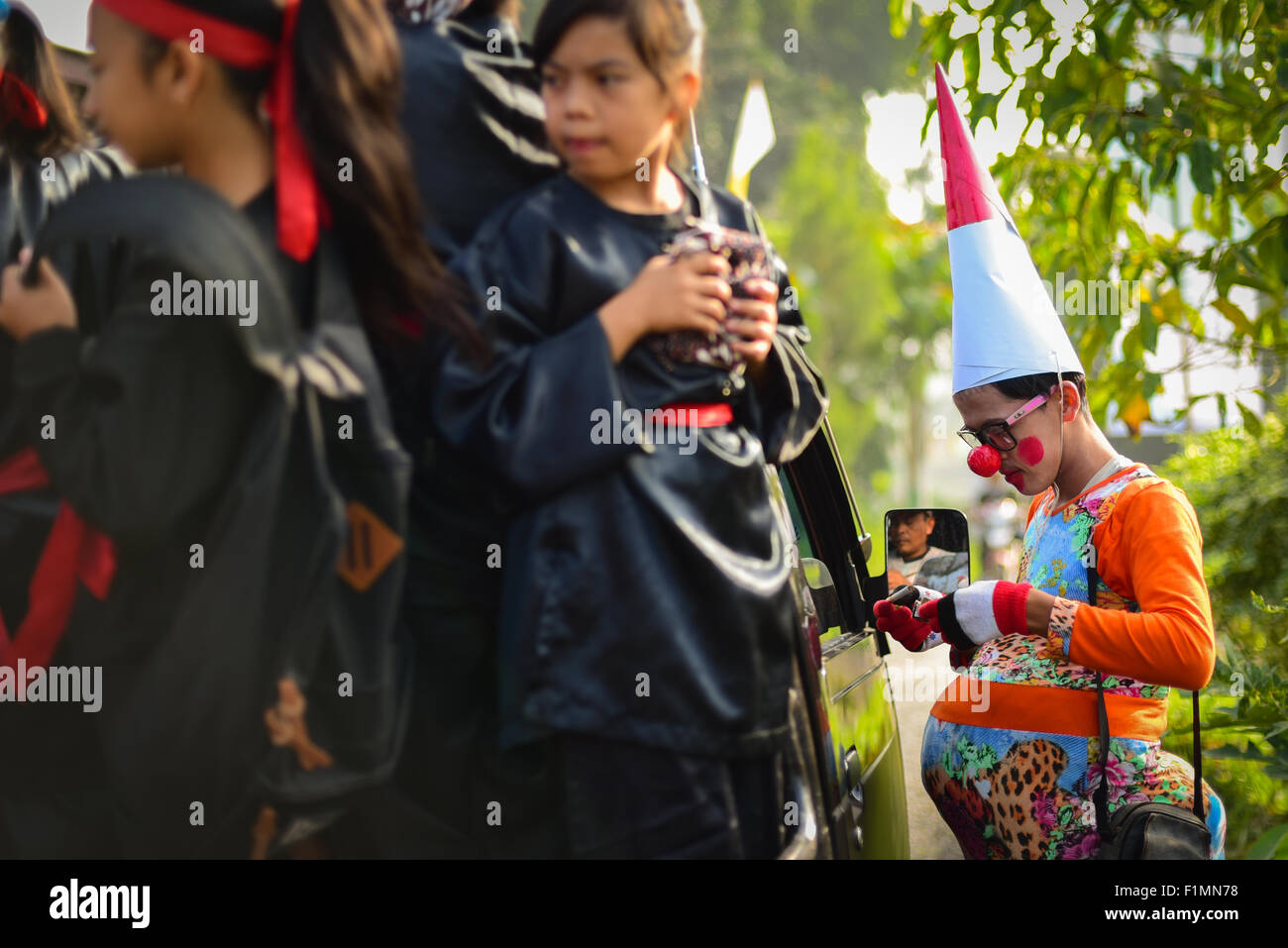 Clown e bambini si preparano per un festival rurale: Festival Sarongge 2015 a Sarongge, Giava Occidentale, Indonesia. Foto Stock