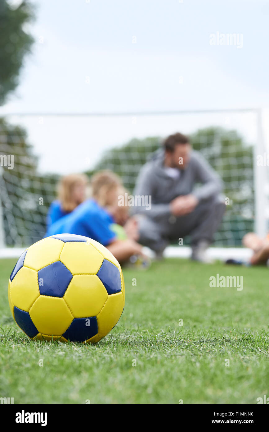 Coach e Team a discutere di tattiche di calcio con la palla in primo piano Foto Stock