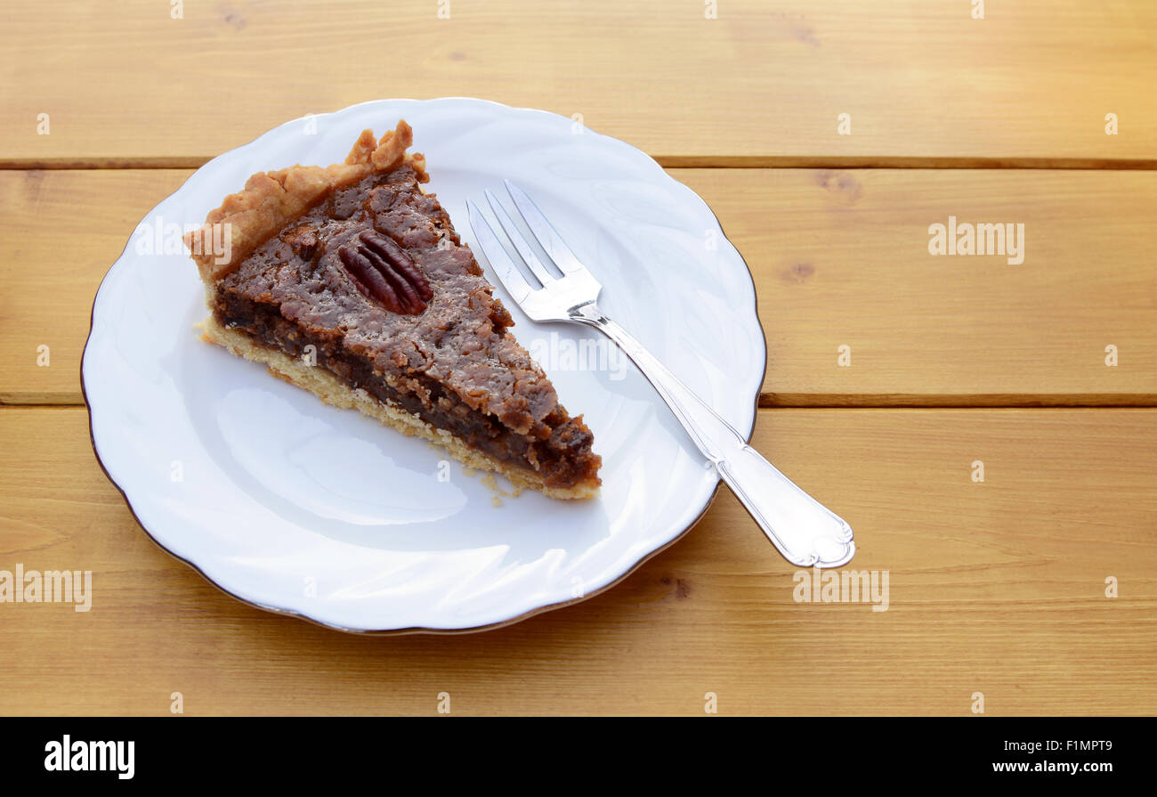 Fetta di appena sfornato torta alle noci pecan su una piastra in Cina con una forcella di dessert Foto Stock