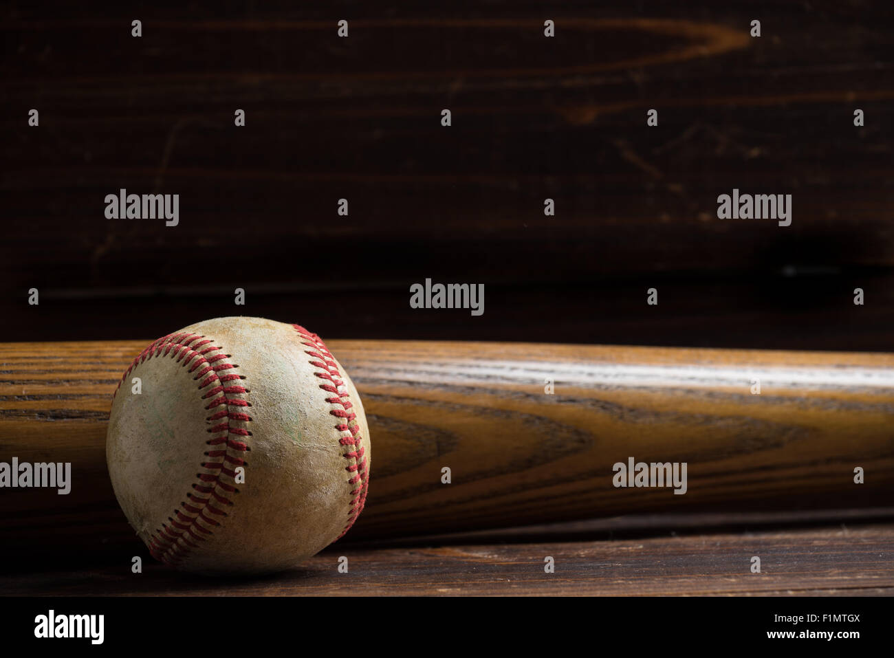 Attrezzatura da baseball: mazza di legno e la sfera su un asse di legno o di sfondo da banco Foto Stock