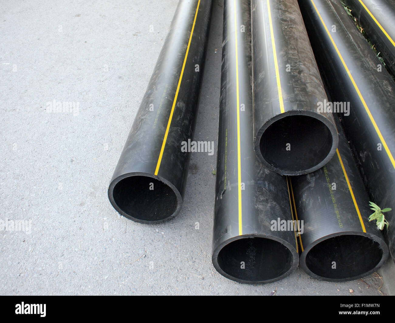 In plastica nera tubi in PVC per la strada, un grande mucchio. Messa a fuoco selettiva con profondità di campo ridotta. Foto Stock