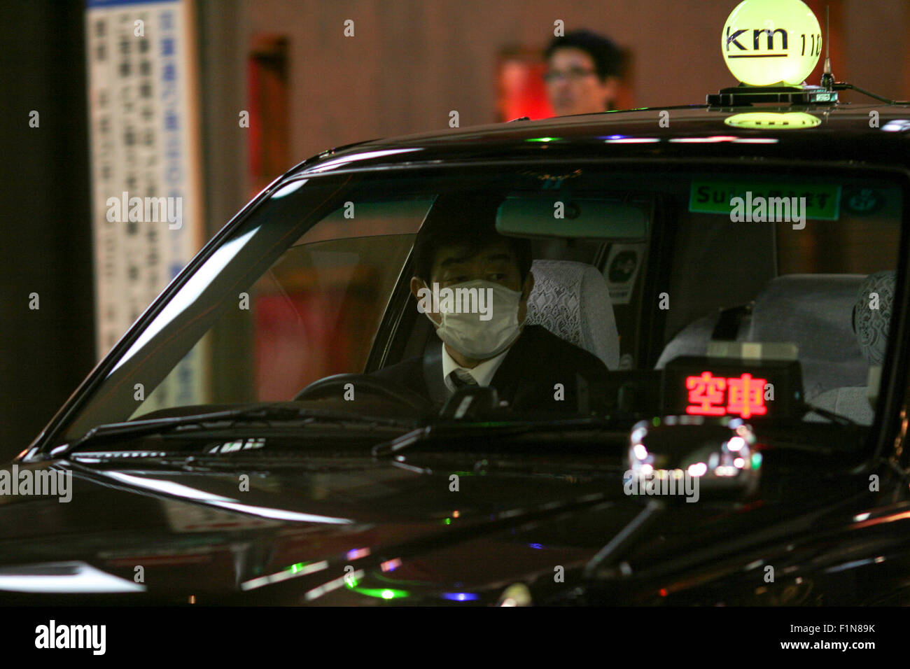 Tokyo taxi nero cab driver di indossare una maschera antipolvere Foto Stock