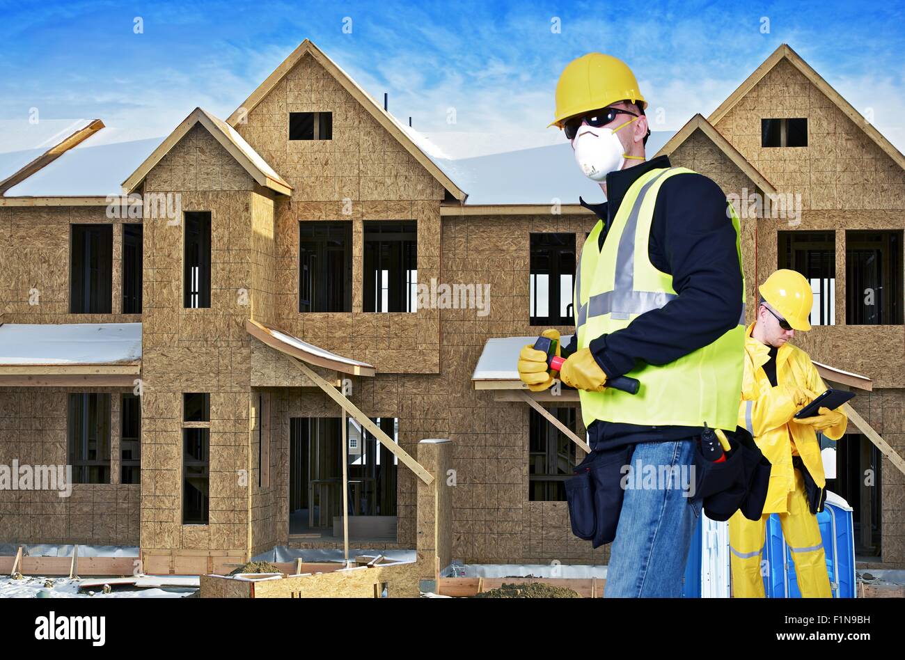 La costruzione dell'edificio sito con due contraente. Un contraente responsabile del sito con la compressa e secondo contraente con un martello piccolo. Foto Stock