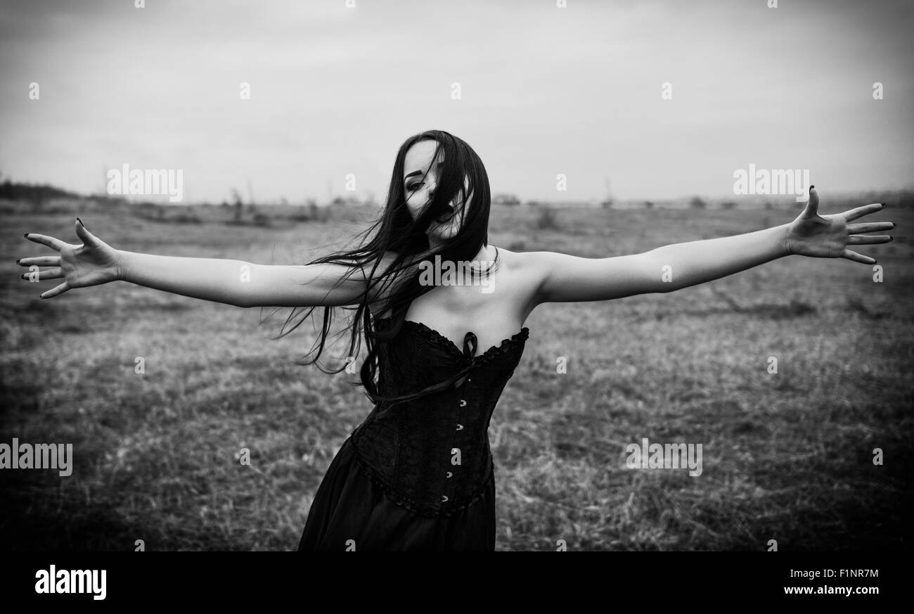 Il pianto triste goth ragazza nel campo autunnale. Foto in bianco e nero Foto Stock