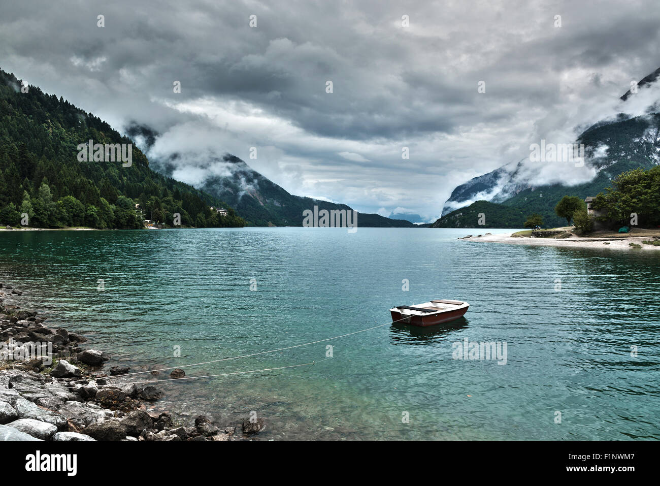 Il lago di Molveno in un nuvoloso pomeriggio estivo con barca, Trentino Alto Adige - Italia Foto Stock