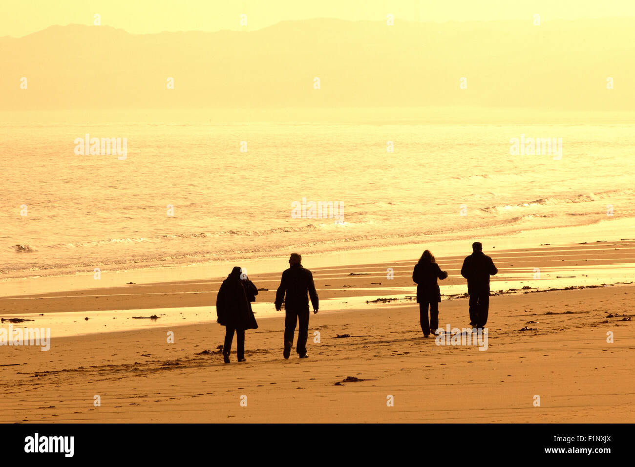 La mattina presto beach walkers a Carbis Bay, Cornwall, Regno Unito Foto Stock