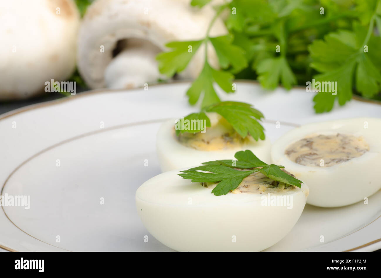 Uova ripiene al prezzemolo sulla piastra bianca Foto Stock