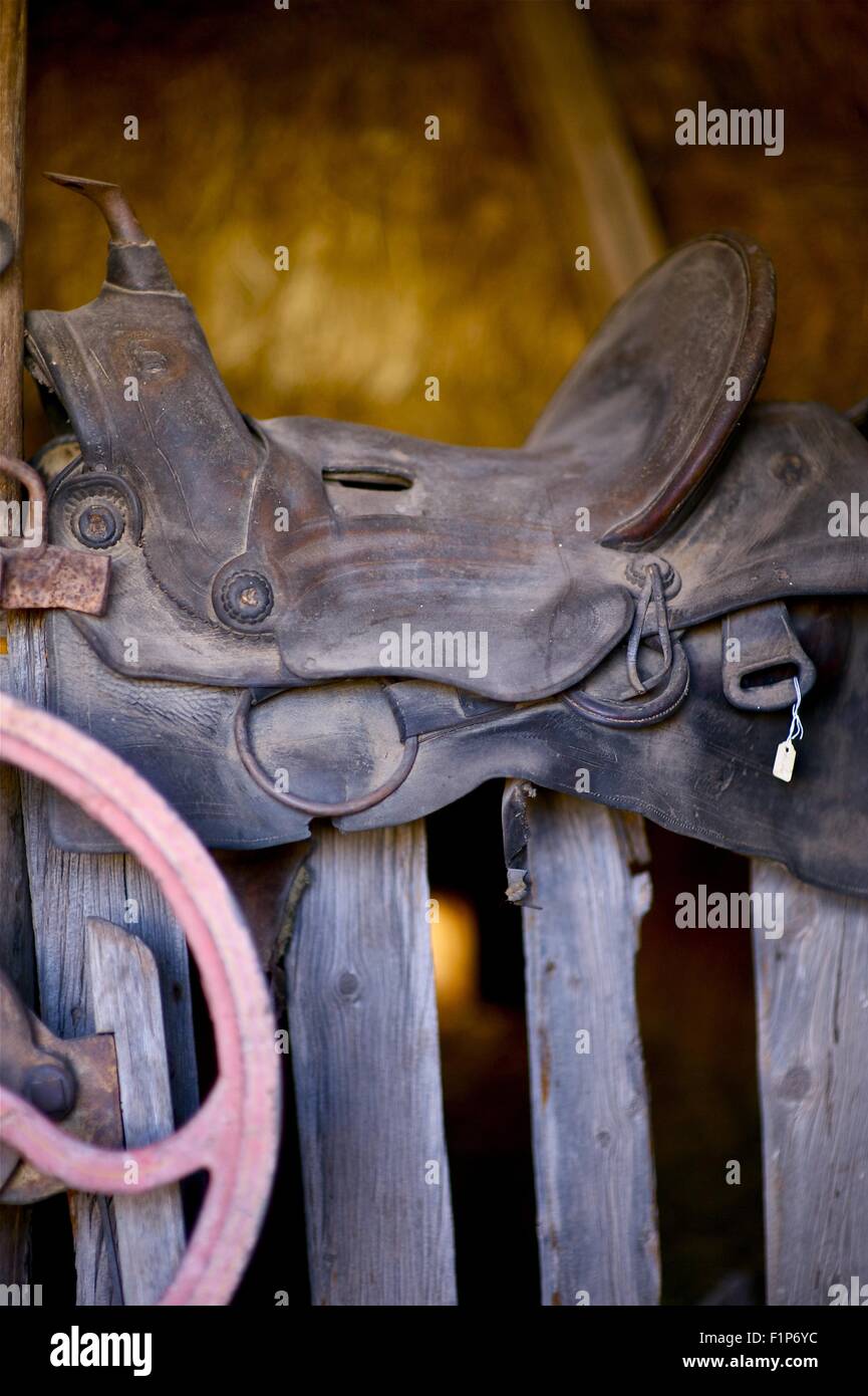 Sella su una staccionata di legno. Sede di cavalli su tavole di legno in un fienile. Foto verticale. Foto Stock