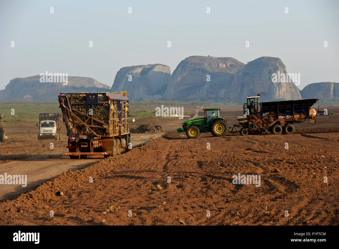 ANGOLA Malange , PAC agroindustriale Pòlo de Capanda, Biocom progetto joint venture brasiliana Odebrecht Angolian e olio di stato società Sonangol, trattore John Deere con macchina di semina di piante piantine di canna da zucchero, la canna da zucchero viene trasformato in una propria fabbrica di zucchero per la produzione di zucchero o di bioetanolo per il carburante Foto Stock